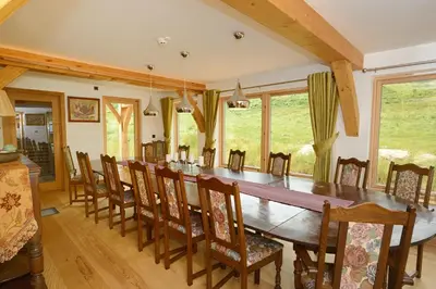a dining room with a long table and chairs at The Lodge at Carrick Castle Estate in Cairndow