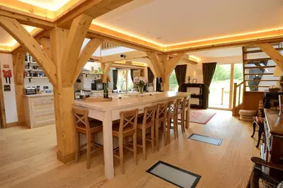 a kitchen with a large island with wooden beams at The Lodge at Carrick Castle Estate in Cairndow