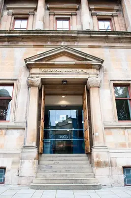 a building with a doorway with stairs in front at The Pipers' Tryst Hotel in Glasgow