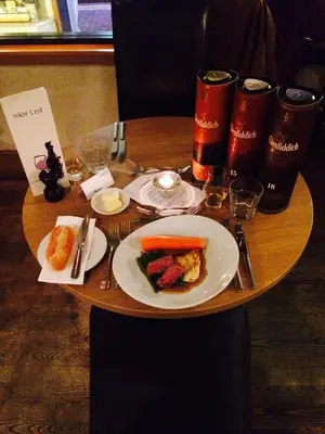 a table with a plate of food and drinks on it at The Pipers' Tryst Hotel in Glasgow