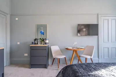 a bedroom with a table and two chairs at Bluebell Studio Glasgow Airport in Paisley