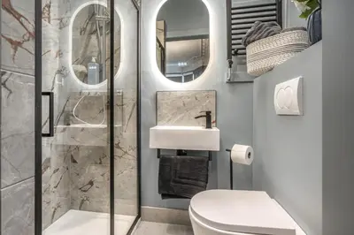 a bathroom with a toilet and a sink and mirrors at Bluebell Studio Glasgow Airport in Paisley