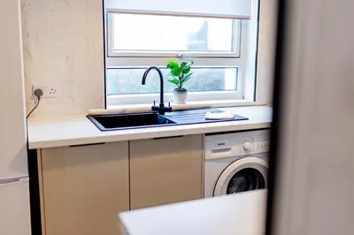 a kitchen with a sink and a window at Welcoming Home in Johnstone, Near Glasgow Airport - Bonnie Lodgings in Johnstone