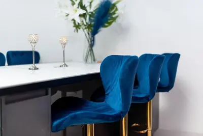a table with blue chairs and a vase of flowers at Spacious modern city centre apartment Castle Views in Edinburgh