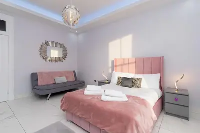 a bedroom with a bed with a chair and a couch at Spacious modern city centre apartment Castle Views in Edinburgh