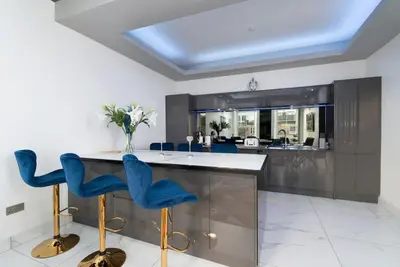 a kitchen with blue chairs and a kitchen island at Spacious modern city centre apartment Castle Views in Edinburgh