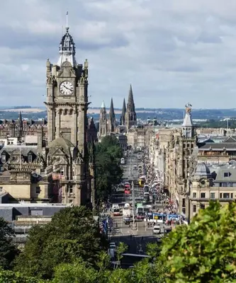 a view of a city with a clock tower at Spacious modern city centre apartment Castle Views in Edinburgh