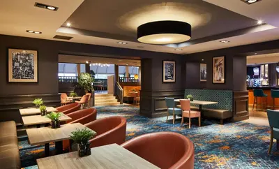 a restaurant with tables and chairs and a bar at Leonardo Edinburgh Murrayfield in Edinburgh