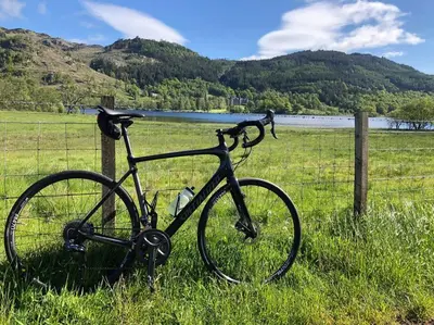 a bike parked next to a fence in a field at Cragside in Callander