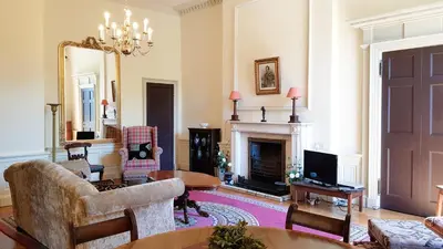 a living room with a fireplace and a tv at Spacious 2-Bedroom Georgian Edinburgh City Apartment in Edinburgh