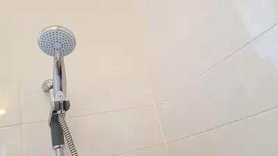 a shower with a shower head in a bathroom at Spacious 2-Bedroom Georgian Edinburgh City Apartment in Edinburgh