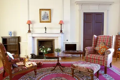 a living room with two chairs and a fireplace at Spacious 2-Bedroom Georgian Edinburgh City Apartment in Edinburgh