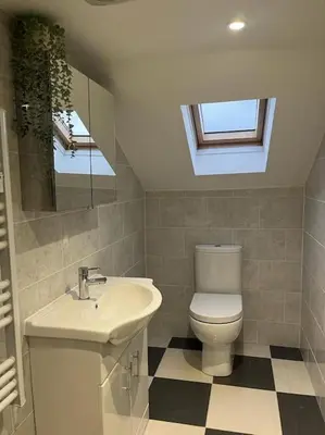 a bathroom with a toilet and a sink and a mirror at Albert House in Airdrie