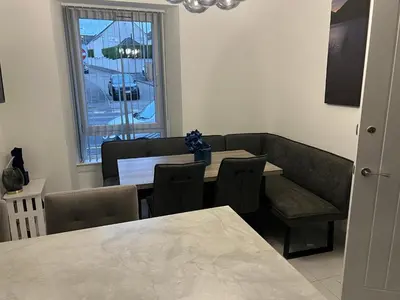a dining room with a table and chairs and a window at Albert House in Airdrie