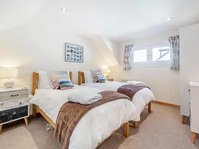 a bedroom with two beds and a desk at Postbox Cottage in Lochranza