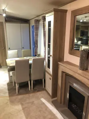 a dining room with a fireplace and a table and chairs at Lovely Caravan in Turnberry