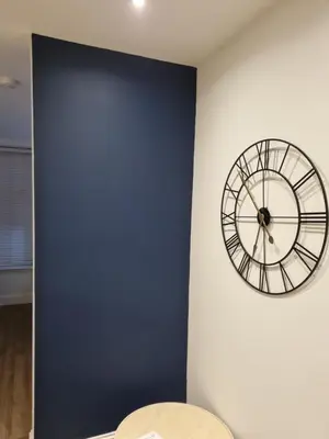 a clock on a wall next to a blue wall at The Rail & Ferry Den in Oban