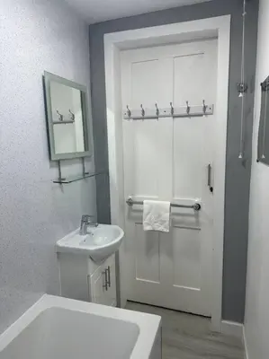 a white bathroom with a sink and a shower at Combie Lane Apartments in Oban