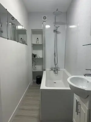 a white bathroom with a tub and a sink at Combie Lane Apartments in Oban