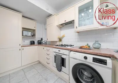 a kitchen with a washer and a washing machine at Bute Apartment by Klass Living Coatbridge in Coatbridge