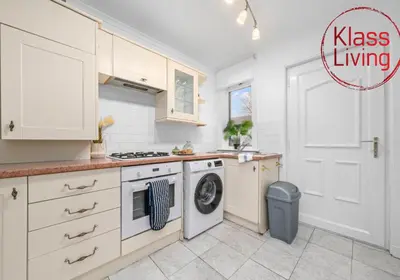 a kitchen with a washer and dryer next to a door at Bute Apartment by Klass Living Coatbridge in Coatbridge