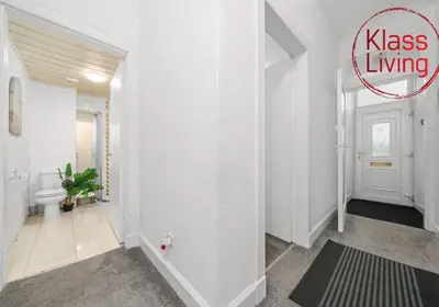 a bathroom with a toilet and a white hallway at Bute Apartment by Klass Living Coatbridge in Coatbridge
