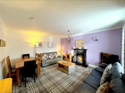 a living room with a couch and a fireplace at Ameliafield Cottage, Prestwick in Prestwick