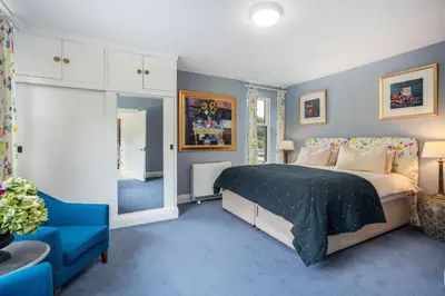 a bedroom with a bed and a blue carpet at Loch View House in Kilfinan