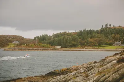 a person on a boat in the water at Loch View House in Kilfinan