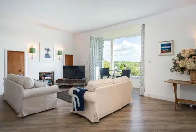 a living room with two couches and a television at Loch View House in Kilfinan