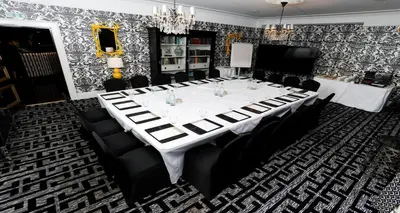 a dining room with a white table and chairs at Gleddoch Golf & Spa Resort in Langbank