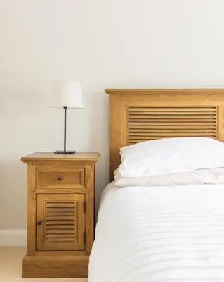 a bed with a wooden headboard and a night stand with a lamp at Luxury Detached Home in Edinburgh