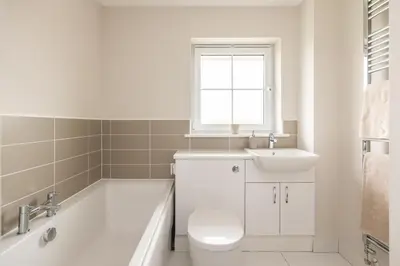 a bathroom with a tub and a toilet and a sink at Luxury Detached Home in Edinburgh