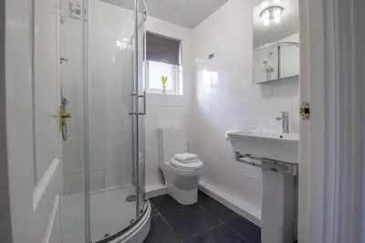 a bathroom with a shower and a toilet and a sink at Park View-modern 2 bed apartment in Motherwell