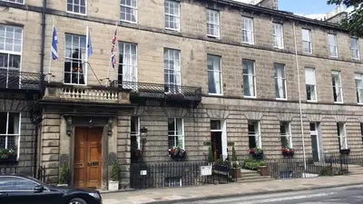 a building with two flags on the side of it at Royal Scots Club in Edinburgh