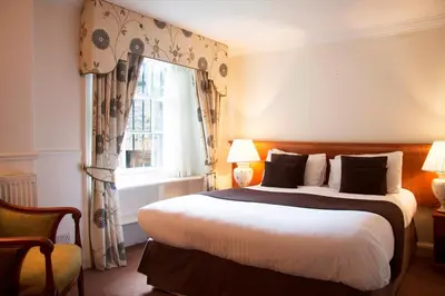 a bedroom with a large bed and a window at Royal Scots Club in Edinburgh