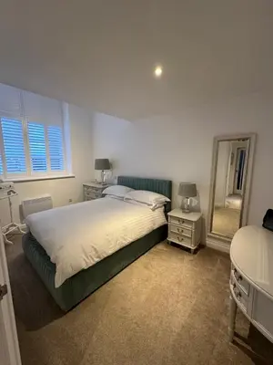 a bedroom with a large bed and a mirror at Luxury Moffat Apartment - High End Furnishing in Moffat