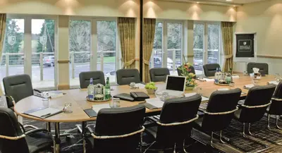 a conference room with a large table and chairs at Macdonald Crutherland House in East Kilbride