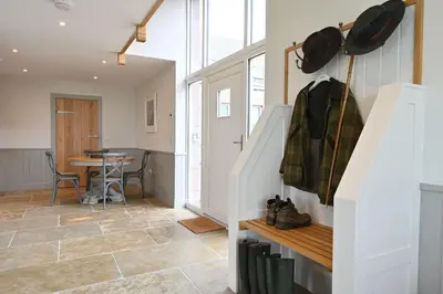 a kitchen and dining room with stairs and a table at Robin Cottage in Buchanty