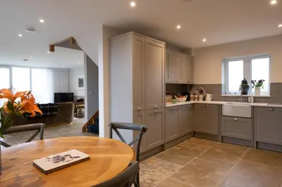 a kitchen with a wooden table and a dining room at Robin Cottage in Buchanty