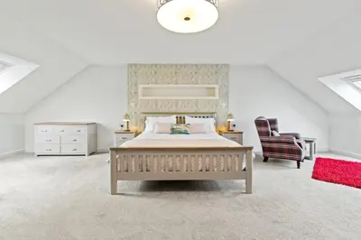 a bedroom with a bed and a desk and a chair at Ferrypoint House in Rhu