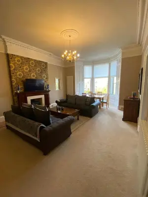 a large living room with couches and a fireplace at Beautiful & bright 2 bed flat Murrayfield in Edinburgh