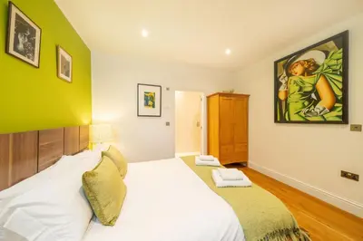 a bedroom with a bed and a painting on the wall at Lochelour Mill Cottage in Perth