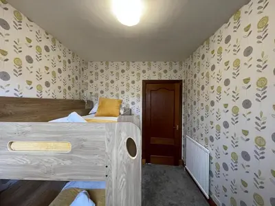 a small room with two beds and a door at 1930s 3Bed House in Quiet Village w/ Large Garden in Bishopton