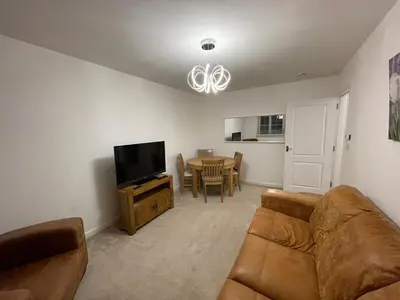 a living room with a couch and a television at Modern 2 Bedroom Flat in Quiet Village w/ Ensuite in Bishopton