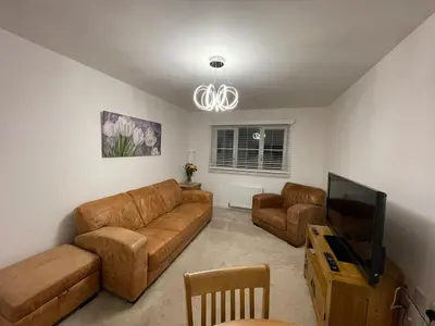 a living room with a couch and a flat screen tv at Modern 2 Bedroom Flat in Quiet Village w/ Ensuite in Bishopton