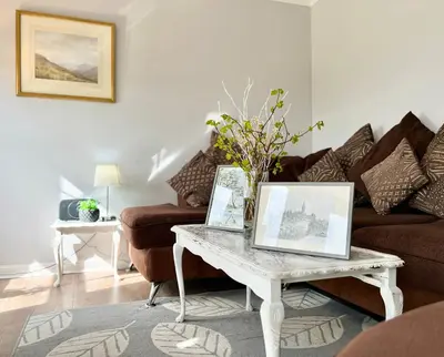 a living room with a table with pictures on it at Luxurious & Modern Apartment in Hawkhead