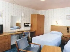 a hotel room with a bed and a desk at Willowbank Hotel in Largs