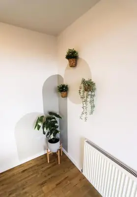 a hallway with potted plants on a white wall at City Views by the Castle, Free Designated Parking. in Stirling