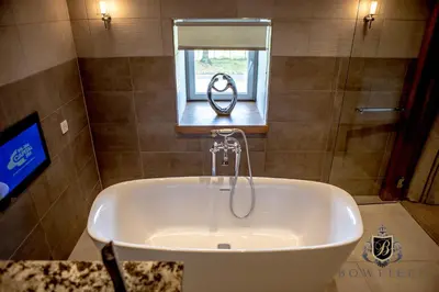 a bath tub in a bathroom with a window at Bowfield Hotel and Spa in Howwood